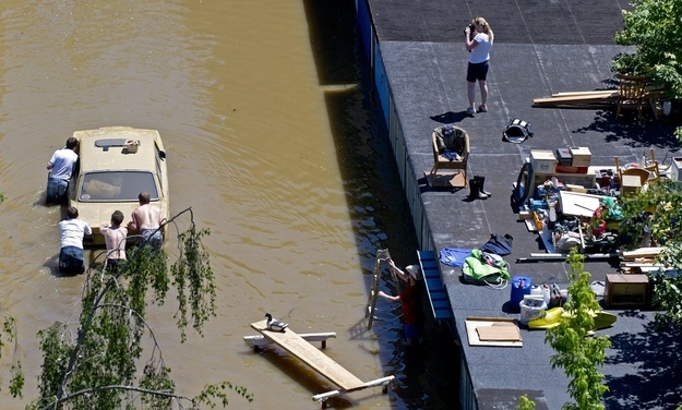Residents push a car out of a garage flooded by the river Elbe in Dresden on June 5.