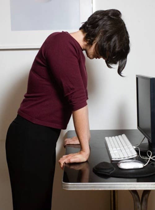 After hunching and typing all day, it'll feel great. Stand with your wrists facing away and your fingers gripping the edge or your desk or table, and slowly press down over your wrists so that your palms go as flat as possible.