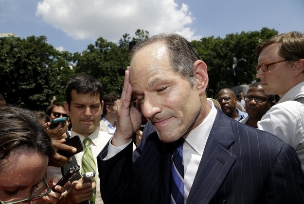 Eliot Spitzer wipes sweat from his face as he is surrounded by media while trying to collect signatures for his run for New York City Comptroller.