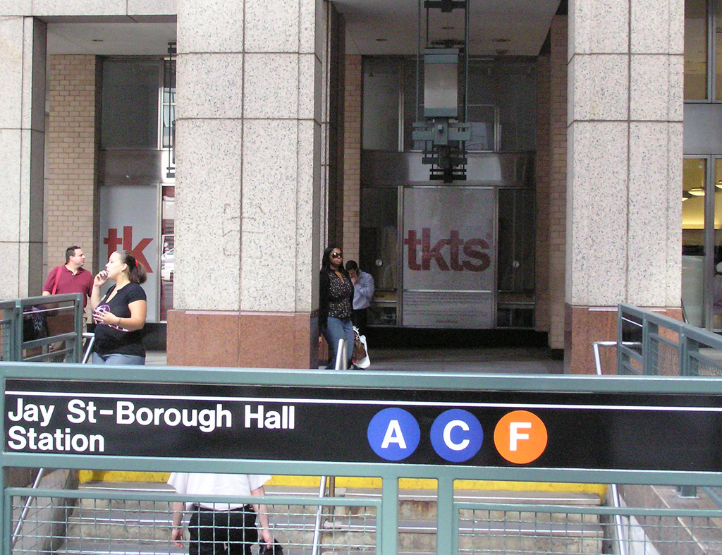 Don't waste time forming sweaty lines on Times Square when you could be at home breast-feeding your baby or in a yoga studio performing downward-facing dog. Instead, take the subway to Wall Street, or haul your ass to Brooklyn, and then buy your tickets there. It's not pimping TDF to report that it has reopened a TKTS satellite booth at a temporary location at the corner of Fulton and South Streets. After sustaining damage in the aftermath of Hurricane Sandy, the permanent TKTS book in the Seaport Marketplace (at the corner of Front and John Streets) is still being renovated. The temporary booth is a pop-up retail container, a convenience to those who work and live in Downtown Manhattan.TDF also operates another satellite TKTS booth in Downtown Brooklyn located at 1 MetroTech Center. At these two locations, lines are shorter. You can check the free TKTS app on your mobile phone to see what's on sale, and still have time to do a cardio spin and a quick shower after grabbing same-day matinee or evening tickets for up to 50% off full price. Here's the problem, however: The fast pass service (mentioned above) works only for the red booths on Times Square. It's not available for either the Brooklyn or Seaport booths, Come to think of it, how inconsiderate of them not to make fast passes available to downtown hipsters, Brooklynites and the rest of us intrepid bargain hunters!