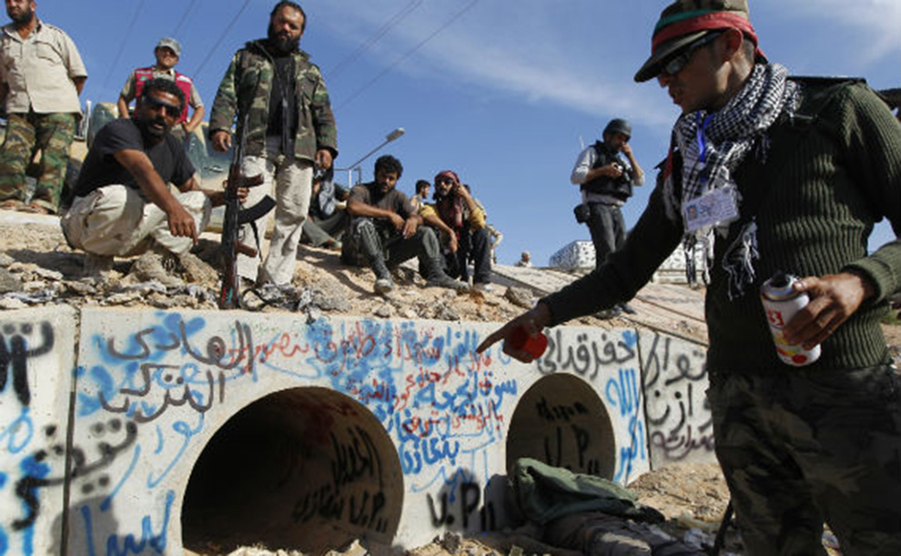 The once-extravagant leader of Lybia Muammar Gaddafi met his extremely violent and public end at the hands of revolutionary fighters after they discovered him wounded, hiding inside of a drainage pipe and mercilessly ignored his please to not shoot.