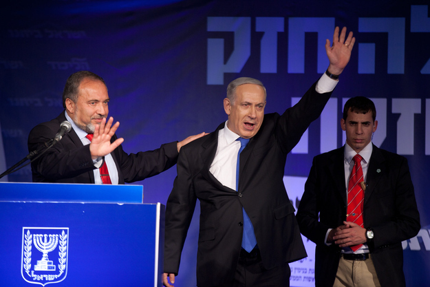 Benjamin Netanyahu waves to his supporters as he arrives with Former Israel Minister for Foreign Affairs Avigdor Liberman at his election campaign headquarters on Tuesday.