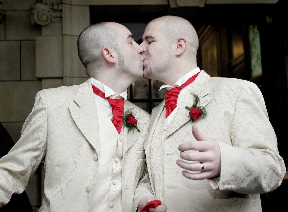 In this 2005 file photo, Henry Edmont Cane, left, and partner Christopher Patrick Flanaghan kiss outisde Belfast City Hall in Northern Ireland after becoming the first male couple to win legal recognition for their civil partnership.