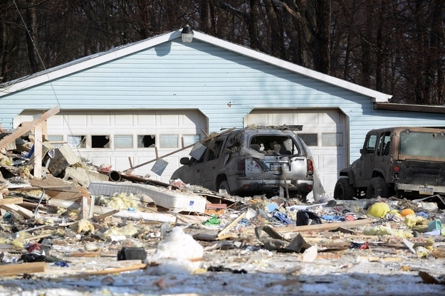 A damaged garage and vehicles adjacent to the house explosion, which was initially believed to be meth lab-related.