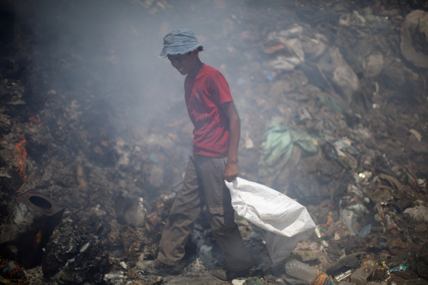 A palestinian boy sifts through a rubbish dump for items of value and recylclable plastic on August 18, 2011 in Gaza City, Gaza.