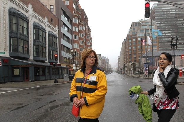 Stephanie Prashad, 22, is the first person escorted back onto Boylston Street through the Hynes, by city worker Christine Sullivan on Tuesday.