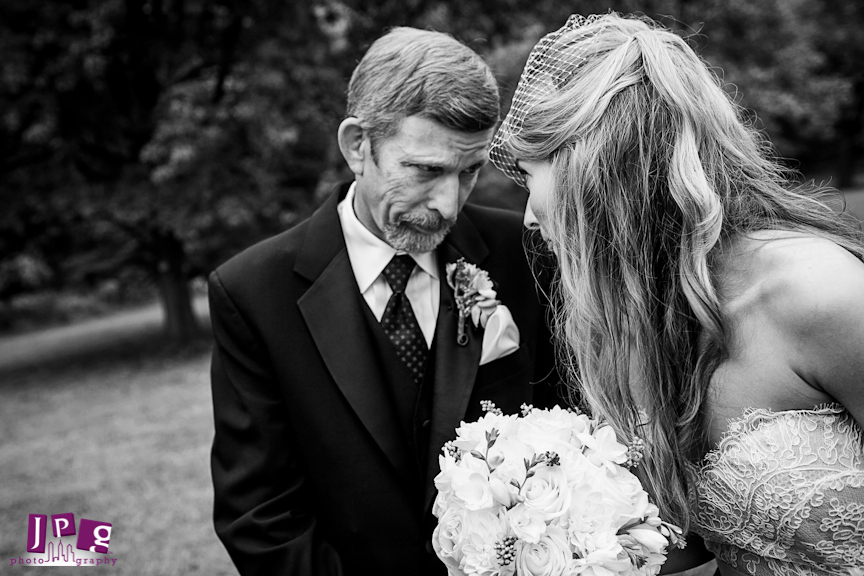 This father sharing a silly face with his daughter in preparation for their serious walk down the aisle.