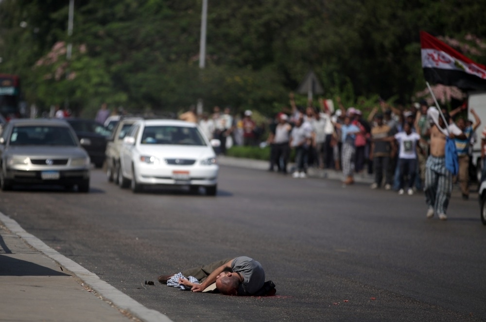 A man lies dead after being shot by Egyptian troops in Cairo, Egypt, Friday, July 5, 2013. Egyptian troops opened fire on mostly Islamist protesters marching on a Republican Guard headquarters Friday to demand the restoration of ousted President Mohammed Morsi, killing at least one. The shooting came as tens of thousands of his supporters chanting "down with military rule" rallied around the country.