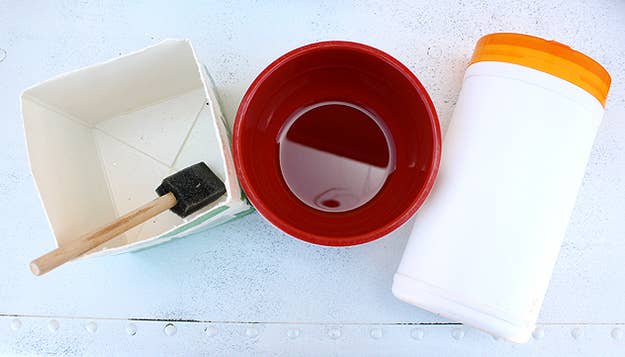 Wearing your gloves, mix concrete and water according to directions on the package. The amount of water varies on the type you purchase. Pour concrete into large container. Place the small container in and place a heavy rock on top so that the container stays inside. Let dry for 24-48 hours. Discard the containers and drill holes into the bottom of the concrete for drainage.