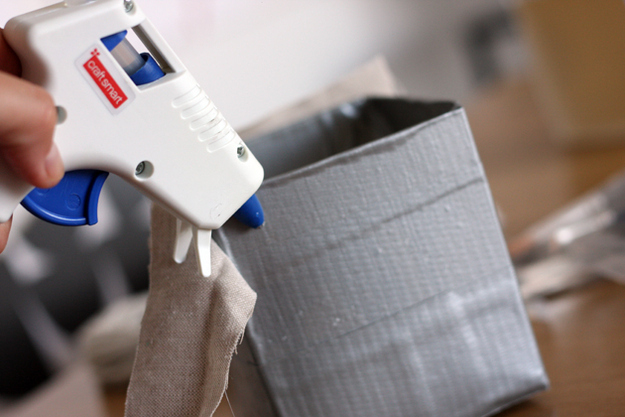Put some duct tape on the bottom side of the box to tape down the pieces of fabric to the base for added security.