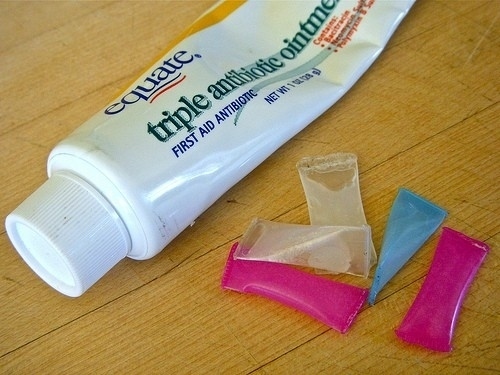 Cut up a straw and fill the pieces up with antibiotic ointment or toothpaste for single-use packets.