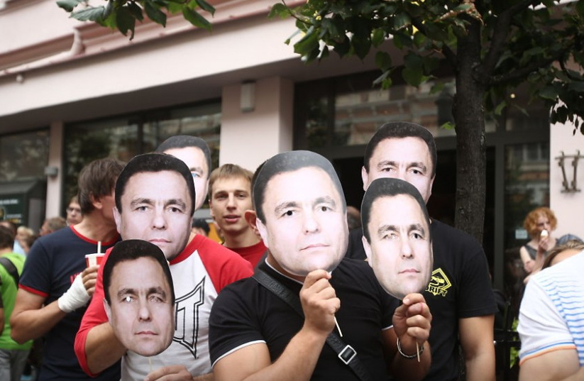 No inicio, só vi um grupo de crianças com máscaras da cara de Grazulis e achei que era suposto ser irónico. Até lhes acenei.Mas há medida que avançávamos mais pessoas apareciam na multidão com a cara dele, em protesto contra a marcha.Só conseguia lembrar-me do filme Being John Malkovich..