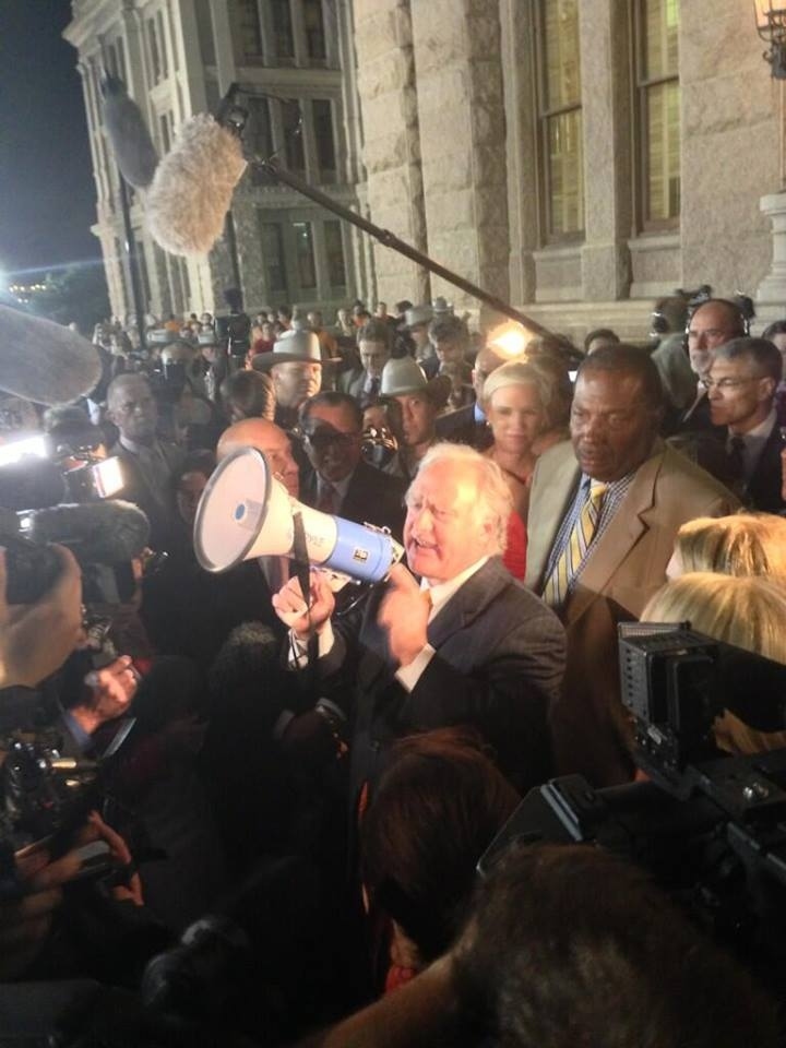 Rep. Kirk Watson speaks to a crowd of protesters.