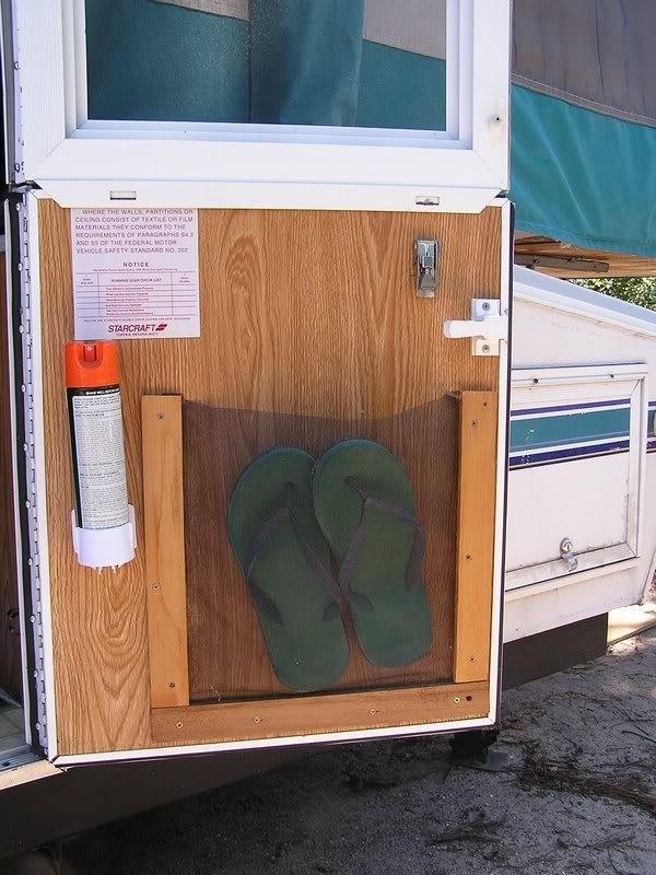 Flip flops attached to the door of an RV using a netting material