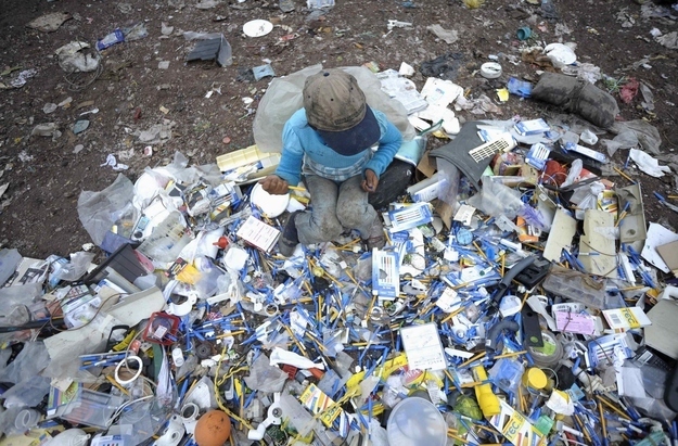 A girl inspects discarded pens at a landfill on the outskirts of Tegucigalpa September 27, 2012. According to the International Labour Organization there are around 215 million children working. Many of them work full-time and do not receive proper nutrition and care.