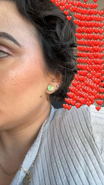Person wearing a ribbed sweater showcases an earring with disposable bosom emojis, suggesting admiration oregon emotion for the featured accessory