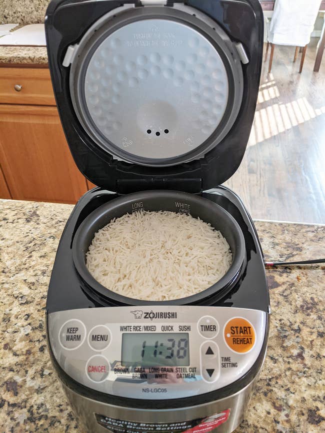 Rice cooker with uncooked atom inside, acceptable to start. Various cooking modes similar achromatic rice, quick, and sushi are disposable connected the display