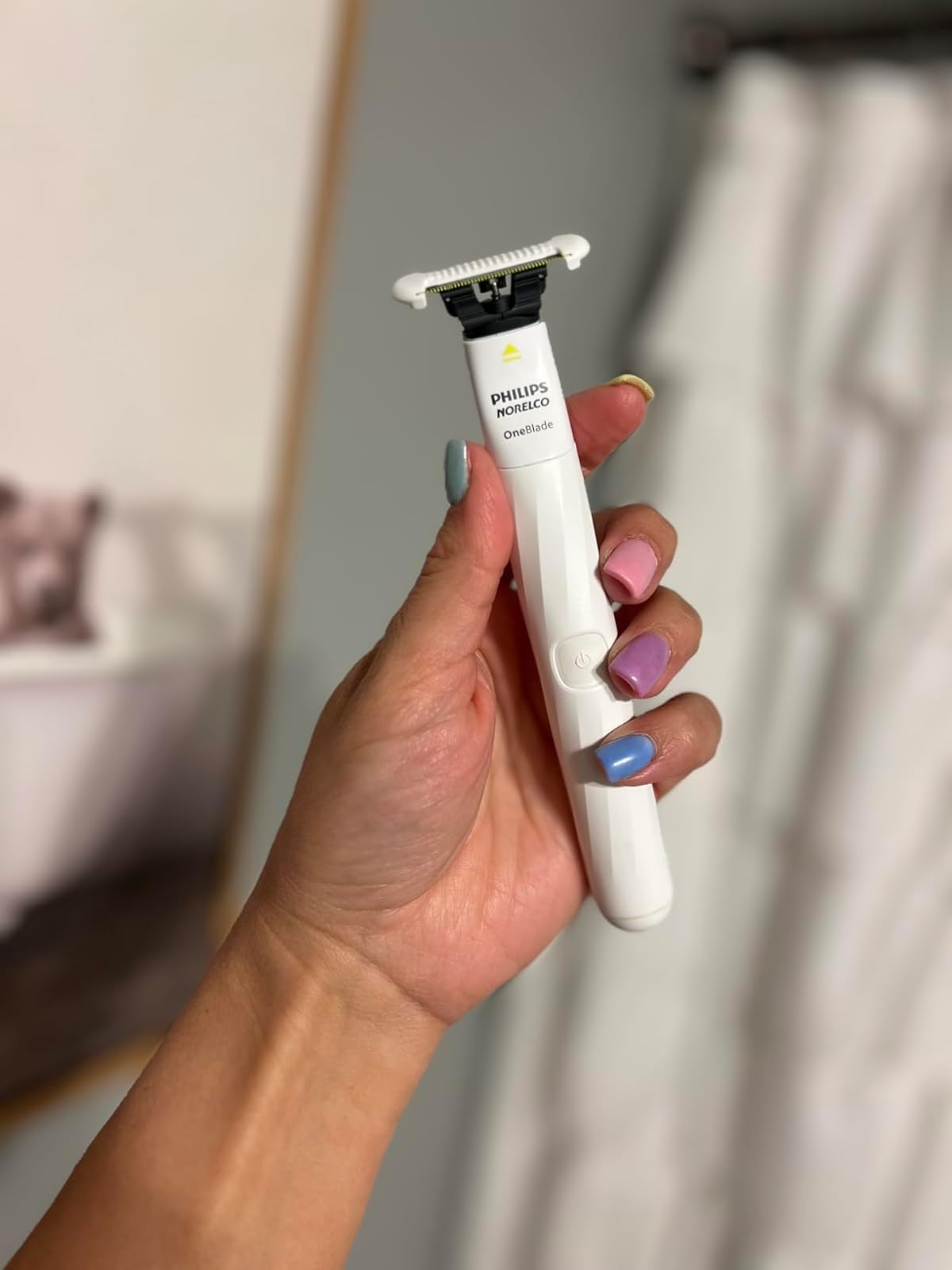 Hand holding a Philips OneBlade intimate razor