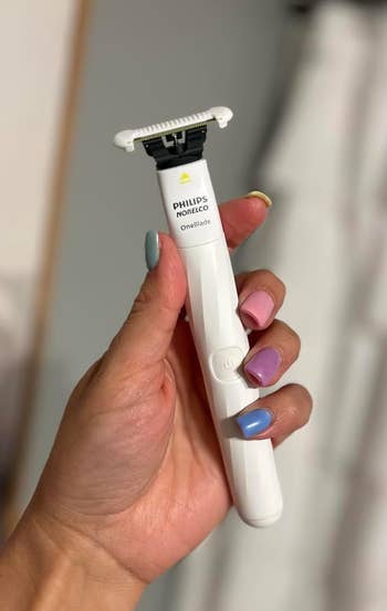 Hand holding a Philips OneBlade intimate razor