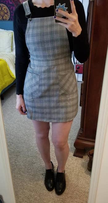 a reviewer wearing the same dress featuring a black and white plaid print 