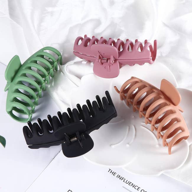 four clips, one green, one pink, one tan, and one black