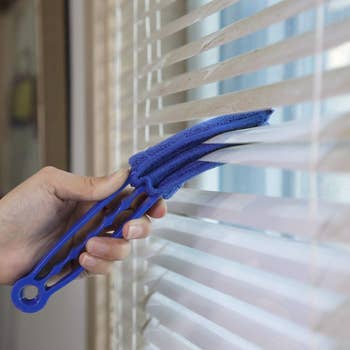 a model using a blue duster on window blinds
