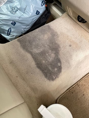 reviewer before image of a huge dark stain in a beige car