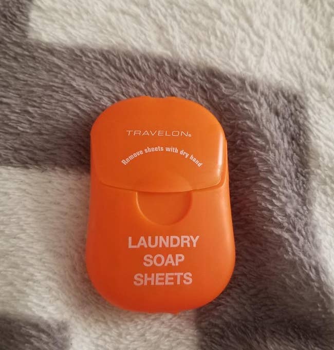 a reviewer photo of the orange container of laundry soap sheets 