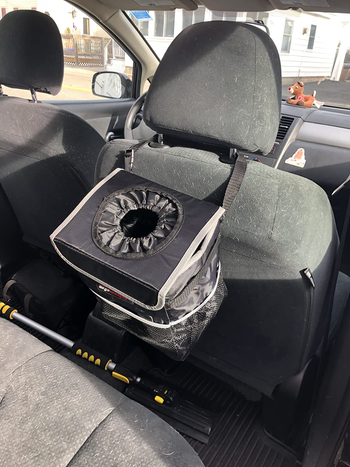black trash can hung on the back of a headrest