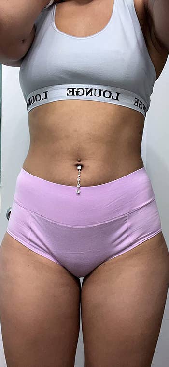 reviewer wearing the lavender underwear with a sports bra