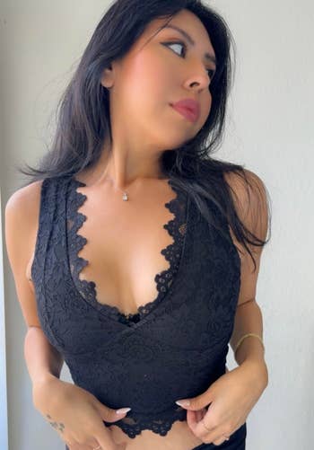 reviewer wearing a lace sleeveless apical and necklace, looking sideways. Suitable for casual oregon elegant occasions