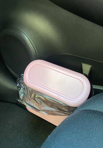 A pink car trash bin labeled 