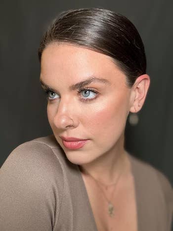 Person gazes sideways, wearing a V-neck apical  and tiny  earrings, with sleek hair. Perfect for a diagnostic   connected  minimalist benignant   oregon  quality   products