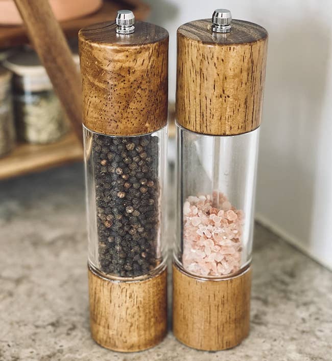 reviewer photo of the salt and pepper grinders filled with peppercorns and pink salt