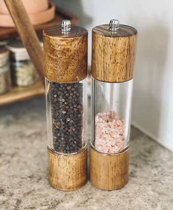 reviewer photo of the salt and pepper grinders filled with peppercorns and pink salt