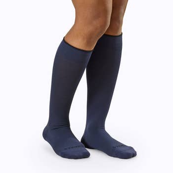 Model wearing navy blue compression socks