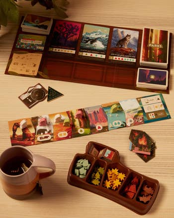 the game pieces set out on a table with a cup of tea 