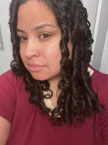 Person with curled hairsbreadth  and a relaxed look  wearing a casual top