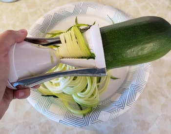 a reviewer using the spiralizer to cut zucchini