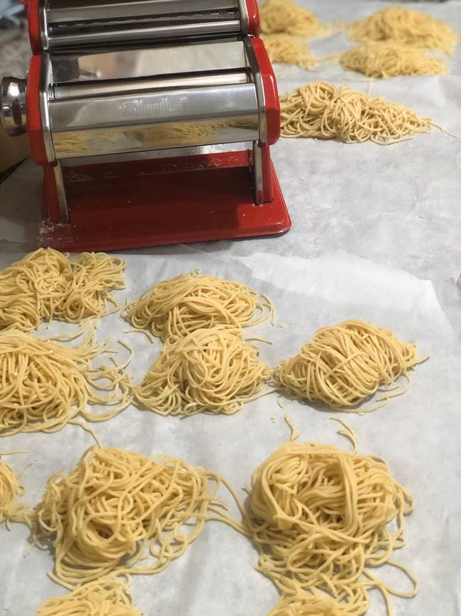 a red pasta machine and bundles of pasta