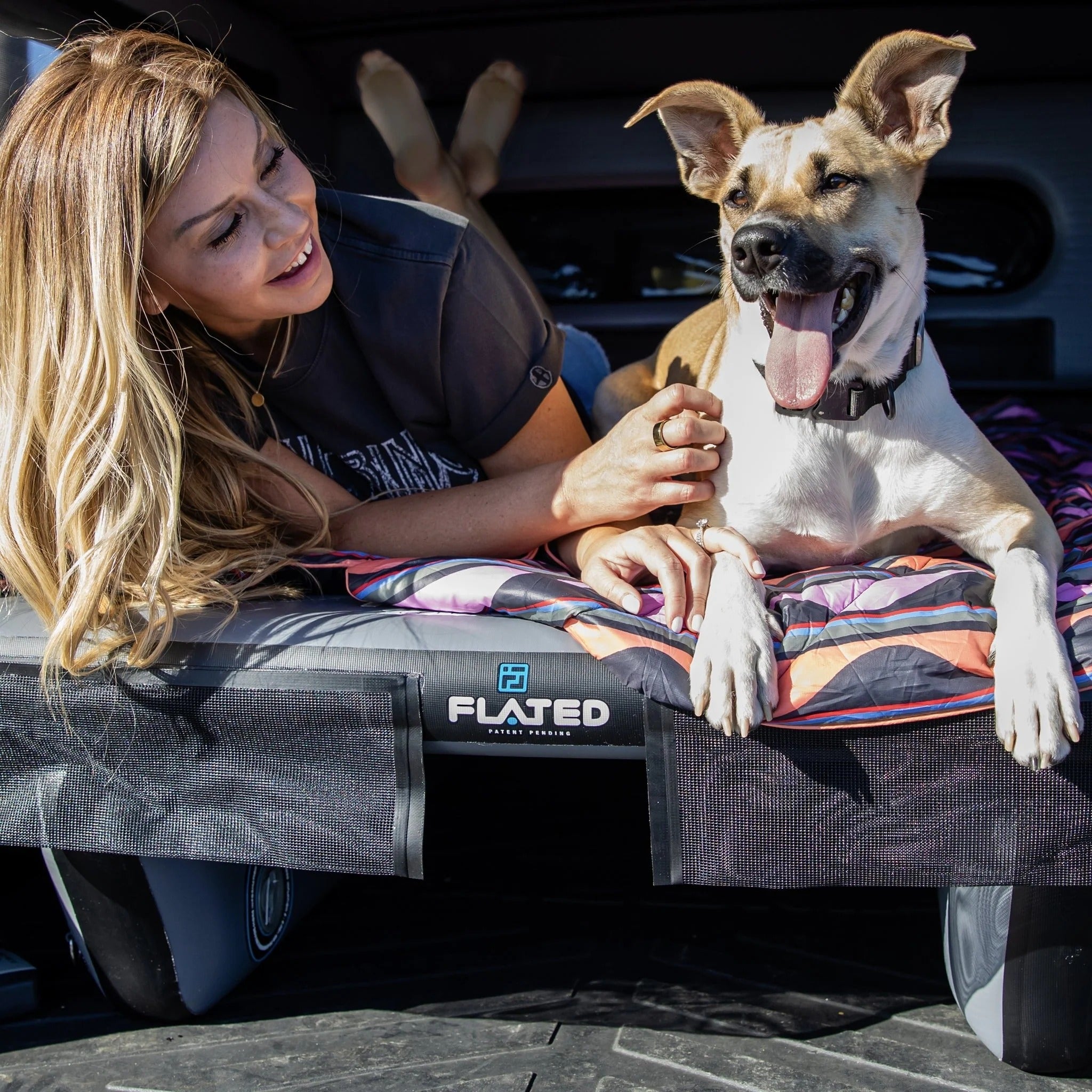 a model and a dog laying on the inflatable platform on a truck bed