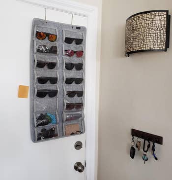 reviewer's gray sunglasses organizer hanging over the door on two metal hooks