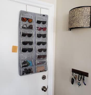 reviewer's gray sunglasses organizer hanging over the door on two metal hooks