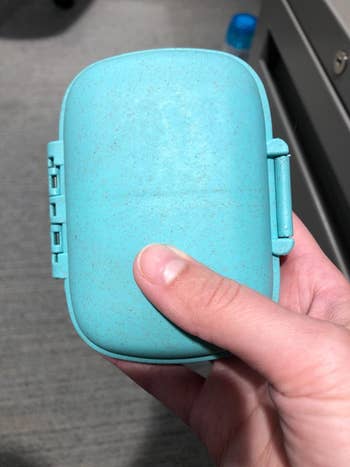 Reviewer holding their closed pill organizer in blue