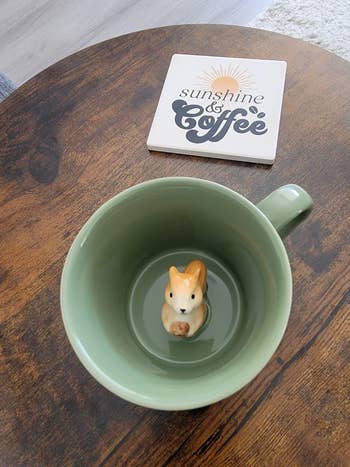 A greenish  cupful  with a ceramic squirrel inside, connected  a array  with a 