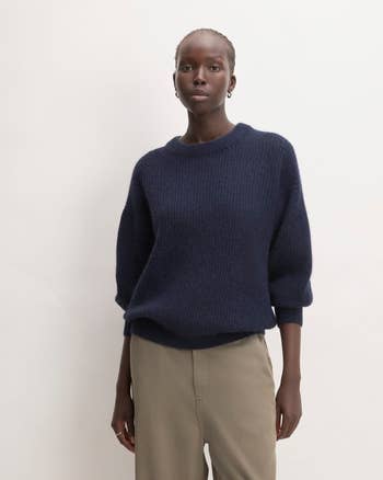 a model in a dark blue oversized sweater