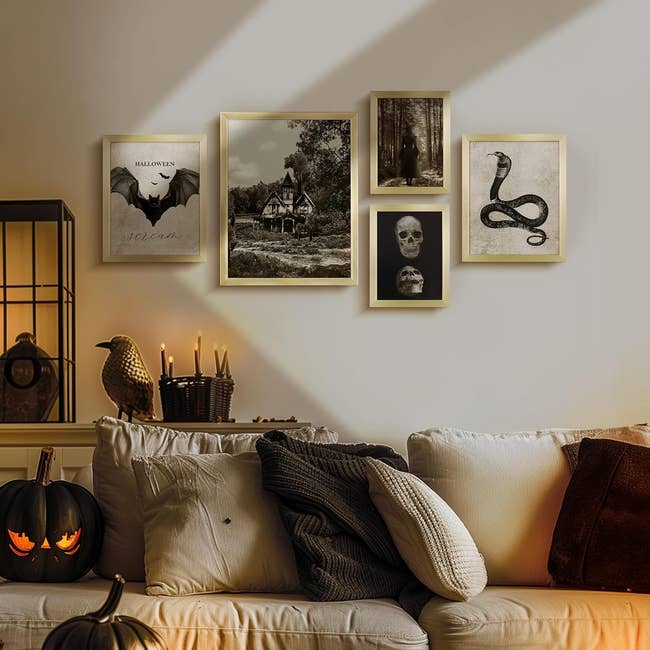 A cozy surviving  country   with a achromatic  sofa  adorned with pillows, surrounded by Halloween-themed partition  art, candles, and a carved pumpkin