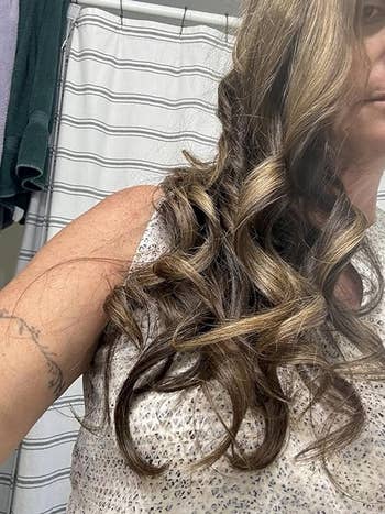 Person with curly hairsbreadth  wearing a sleeveless textured apical  is partially visible, lasting  against a striped background