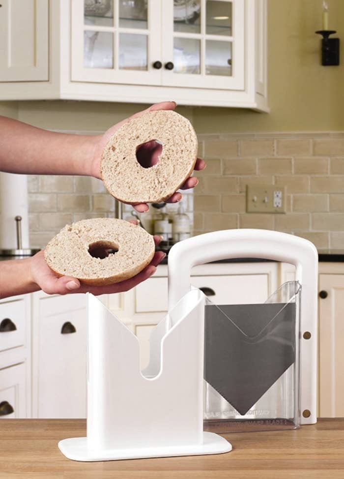 person holding bagel in half that was cut with bagel slicer