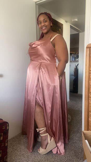 Woman astatine  location  wearing a flowing satin gown and wedge sandals, lasting  confidently and smiling